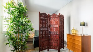Ein Zimmer mit einem Holzschrank, einem Blumentopf und einem Zierbildschirm.