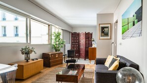 Ein modernes Wohnzimmer mit einer Couch, einem Couchtisch und einem großen Fenster.