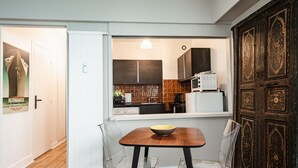 Eine moderne Küche mit einem Holztisch, klaren Stühlen und Blick in den Essbereich.