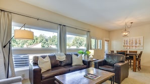 A living room with a brown leather sofa, a coffee table, and a dining area with a wooden table and chairs. - East Vail Condo w/ Pool, Hot Tub, & Free Bus Stop (Vail)