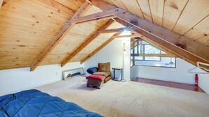 A room with a sloped ceiling, a bed, a chair, a small table, and a window. - Hike, Boat & Ski: South Lake Tahoe Home (South Lake Tahoe)