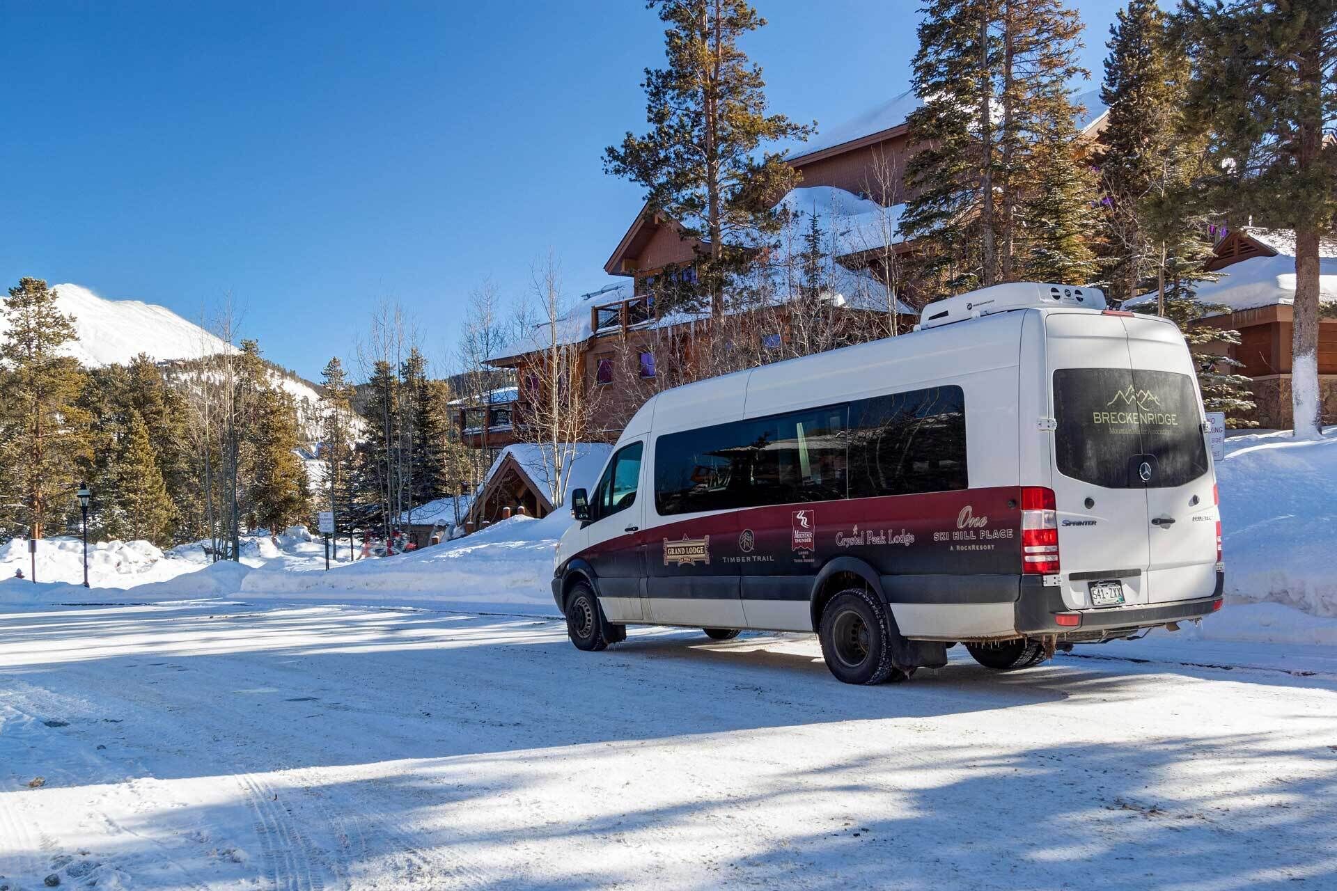 A white van with red and black branding parked on a snow-covered road.