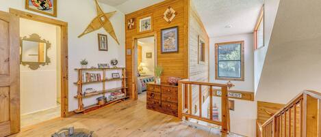A spacious living area with wooden floors, a large starfish decoration, and a staircase leading to an upper level.
