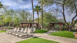 A patio area with lounge chairs and a covered seating area, surrounded by well-maintained grass and trees. - Walk to Papago Park: Central Phoenix Condo (Phoenix)