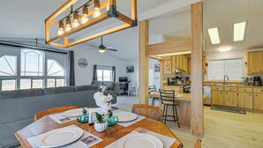 Un salon moderne comprenant un coin repas, une cuisine et de grandes fenêtres.
