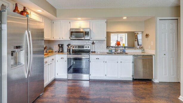 A modern kitchen with stainless steel appliances, white cabinetry, and hardwood flooring. - Ponte Vedra Beach Family Home: 2 Mi to Beaches! (Ponte Vedra Beach)