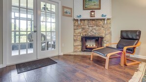 A room with a stone fireplace, a leather chair, and a large glass door leading outside. - Ponte Vedra Beach Family Home: 2 Mi to Beaches! (Ponte Vedra Beach)