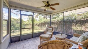 A sunroom with large windows, wicker furniture, and a ceiling fan. - Ponte Vedra Beach Family Home: 2 Mi to Beaches! (Ponte Vedra Beach)