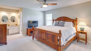 A bedroom with a wooden bed, a ceiling fan, a TV, a nightstand, and a dresser. - Ponte Vedra Beach Family Home: 2 Mi to Beaches! (Ponte Vedra Beach)