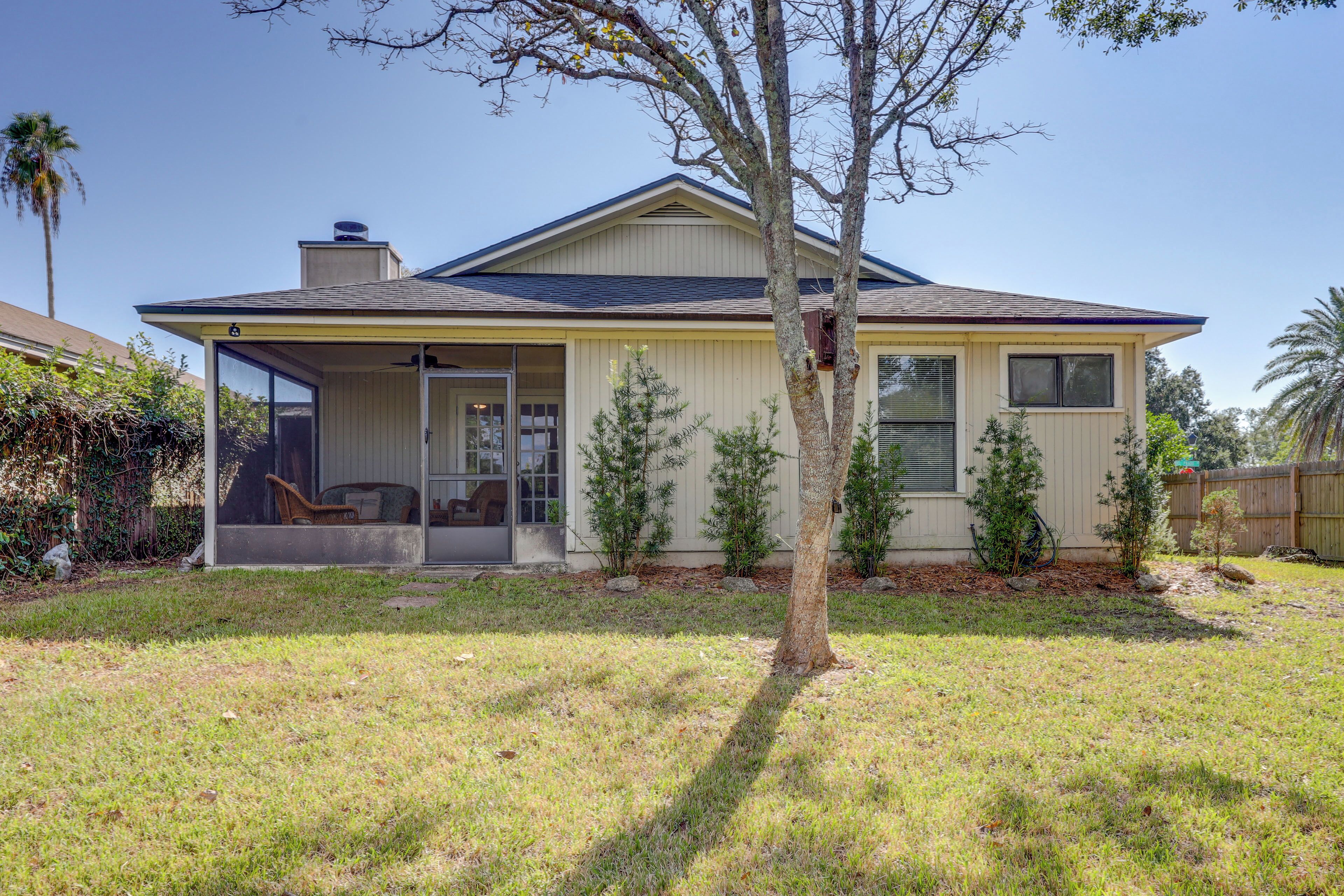 A single-story house with a covered porch, a chimney, and a small tree in the front yard.