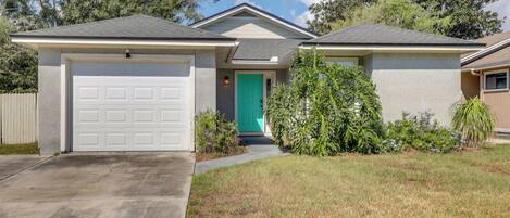 A two-story house with a garage, a front door, and a small porch.