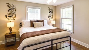 A bedroom with a bed, two bedside tables with lamps, a ceiling fan, and two windows with blinds. - Charming Tullahoma Stay w/ Great Walkable Location (Tullahoma)