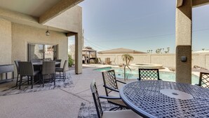 Un patio al aire libre con piscina, mesa y sillas.