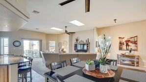 Amplia sala de estar con mesa de comedor, sillas, sofá y televisor.