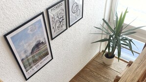 A staircase with wooden steps and a wooden handrail, leading to a landing with framed artworks on the wall. - Behagliches Haus mit Kamin (Monschau)