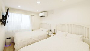 A hotel room with two beds, a TV mounted on the wall, an air conditioning unit, and a bedside table with a lamp. - Rental villa with private sauna with ocean view (Yokosuka City)