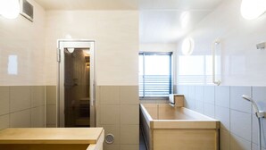 A modern bathroom with a shower, toilet, and sink.
