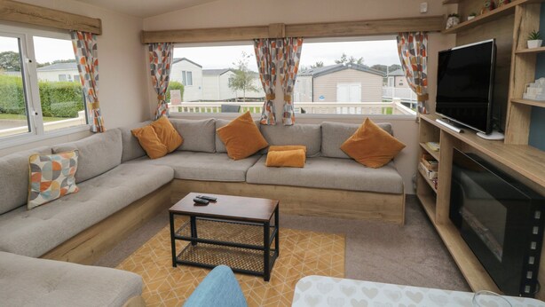A cozy living room with a sofa, coffee table, and TV.