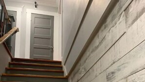 A staircase with wooden steps and a grey wall with a textured pattern. - Suite n °1 au Séjour Knowlton (Knowlton)
