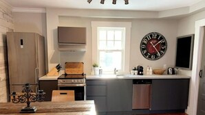 A compact kitchen with a central island, a built-in oven, and a dishwasher. - Suite n °1 au Séjour Knowlton (Knowlton)