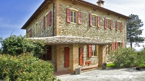 A stone building with red shutters, a stone roof, and a small porch. - Villa Piandisette - Four Bedroom Villa, Sleeps 10 (Cetona)