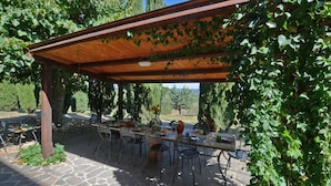 An outdoor dining area with a pergola, stone flooring, and a view of the countryside. - Villa Piandisette - Four Bedroom Villa, Sleeps 10 (Cetona)