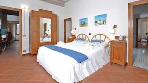 A bedroom with a large bed, wooden headboard, two bedside tables, a wardrobe, and a mirror. - Villa Piandisette - Four Bedroom Villa, Sleeps 10 (Cetona)