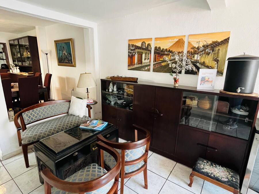 Uma sala de jantar com mesa redonda, cadeiras e um aparador com portas de vidro.