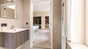 Een moderne badkamer met een grote spiegel, een wastafel en een douchecabine.
