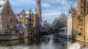 Un canal cubierto de nieve con edificios históricos a ambos lados.