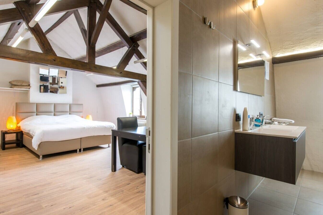 Ein Schlafzimmer mit einem Bett, einem Nachttisch und einem Schreibtisch mit Stuhl.