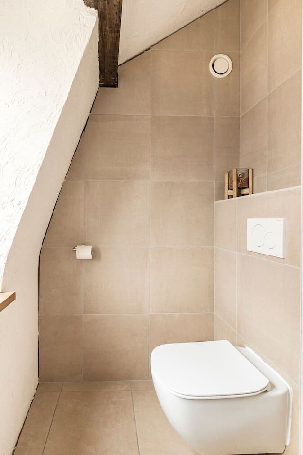 Une petite salle de bain moderne équipée de toilettes, d’une douche et d’un porte-serviettes.