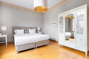 A bedroom with a bed, bedside tables, a wardrobe, and a hanging light fixture.