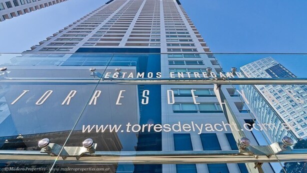 A high-rise building with a glass facade and the text "TORRES DE L" visible. - Puerto Madero Piso 20 Vista al Rio  (Buenos Aires)