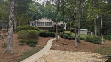 A house with a stone pathway leading to a dock.