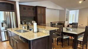 A modern kitchen with granite countertops, stainless steel appliances, and dark wood cabinetry. - Lakefront Home for Spring and Summer Getaways! (Eatonton)