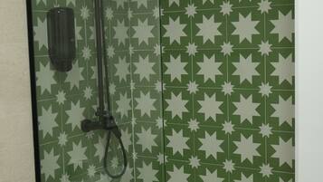 A bathroom with a shower, toilet, and a green star-patterned wall.