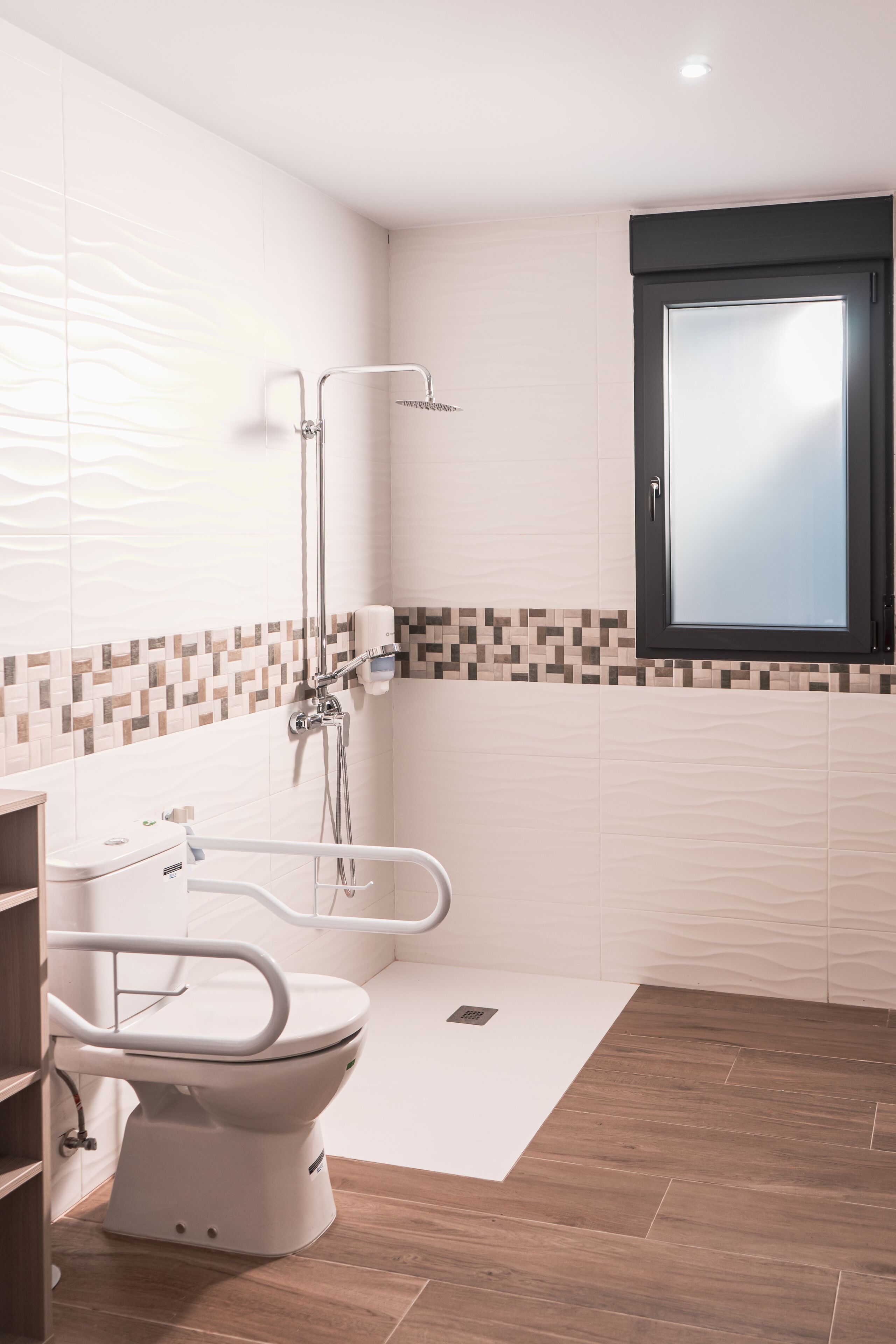 Un baño moderno con inodoro, ducha y ventana.
