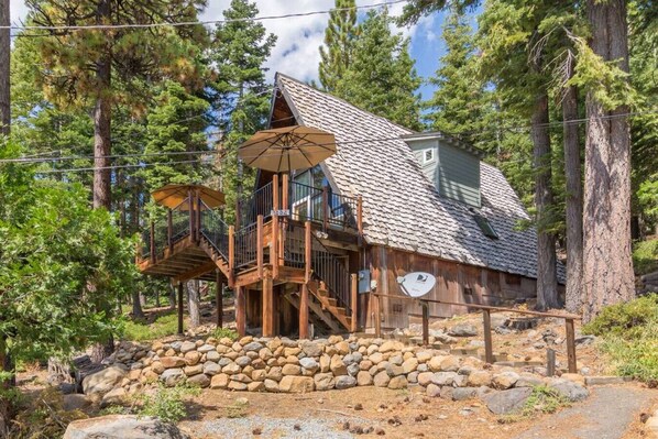 A rustic cabin with a stone foundation, wooden deck, and a satellite dish. - Pet Friendly with Big Views! (Tahoe City)