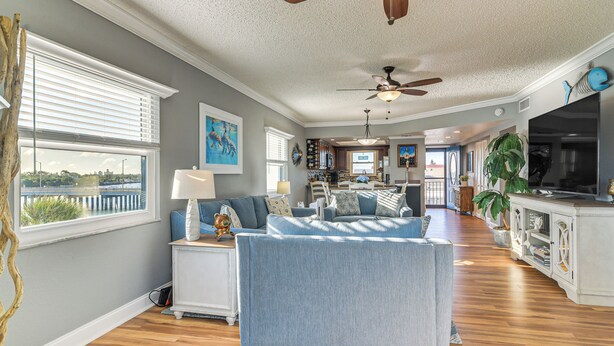 A spacious living room with a large sofa, a dining area, and a kitchen. - Pool, Beach Access: Waterfront Treasure Island Gem (Treasure Island)