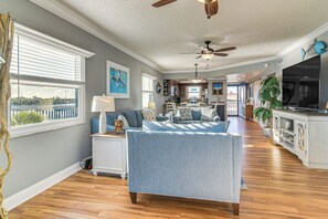 A spacious living room with a large sofa, a dining area, and a kitchen. - Pool, Beach Access: Waterfront Treasure Island Gem (Treasure Island)
