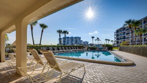 A poolside area with lounge chairs, a swimming pool, and a view of a high-rise building in the background. - Pool, Beach Access: Waterfront Treasure Island Gem (Treasure Island)