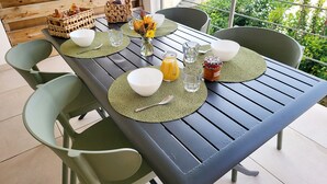 A dining table set with green placemats, white bowls, and a jar of jam. - Une Pause... Quelque Part en Tout Compris (Linguizzetta)
