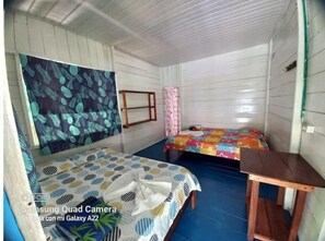 Simple, functional space with two beds and a small table.