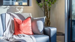 A modern living room with a sofa, a round coffee table, and a potted plant.