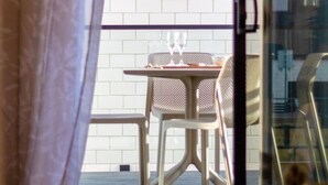 Ein Zimmer mit einer Schiebeglastür, die zu einem Außenbereich mit Tisch und Stühlen führt.