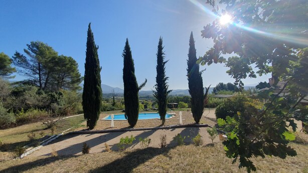 A pool area with four tall cypress trees, a clear sky, and distant mountains. - Superbe Propriété Avec vue Imprenable, Piscine, jeu de Boules au Cœur du Luberon (Saint Saturnin lès Apt)