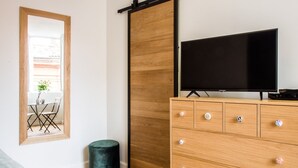 A modern living room with a wooden cabinet, a flat-screen TV, and a sliding door.