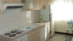 A kitchen with white cabinets, a sink, a stove, and a refrigerator. - Bel Appartement T2 Avec Balcon Donnant Plein sud sur la Chaîne des Pyrénées (Font-Romeu-Odeillo-Via)