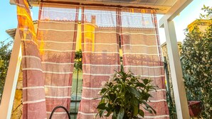 A covered outdoor area with a ceiling fan, striped curtains, and potted plants. - A casa di Oba, vacation home a stone's throw from the sea in Nora, Pula, Sardinia (Pula)